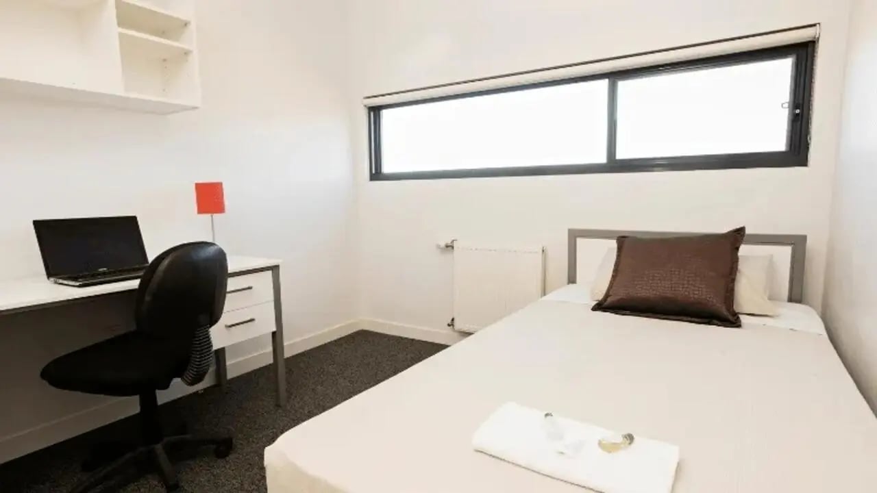 Desk laptop chair shelves bed pillow bedroom at Western Sydney University Campbelltown Village in Sydney Student Accommodation