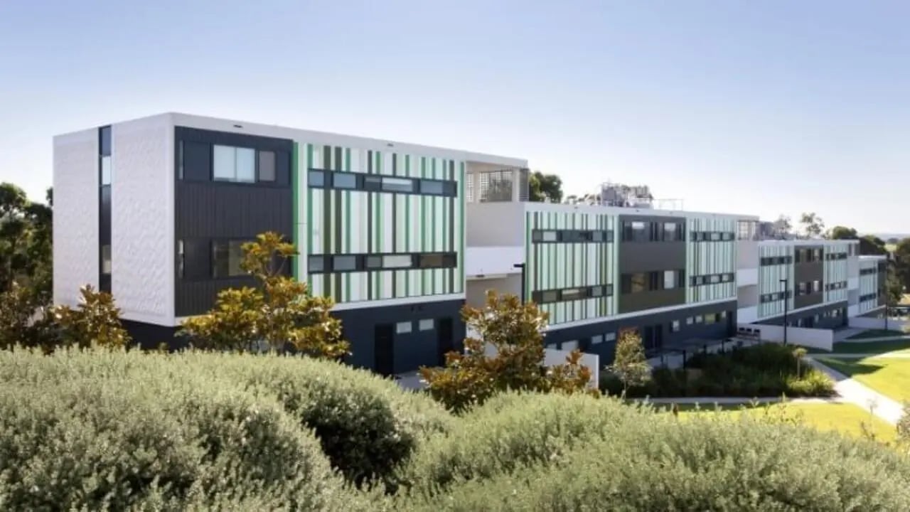 Modern multi story building with green accents exterior at Western Sydney University Campbelltown Village in Sydney Student Accommodation