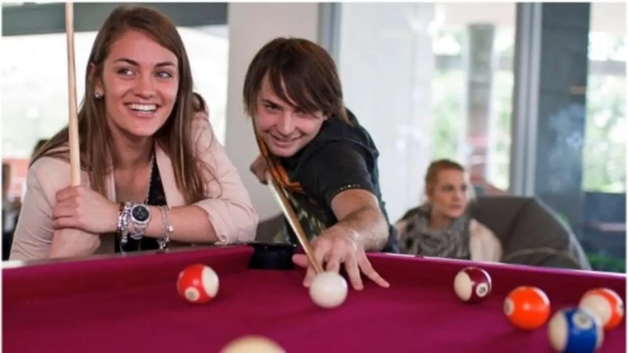 Students playing pool billiard table recreation area at Western Sydney University Campbelltown Village in Sydney Student Accommodation
