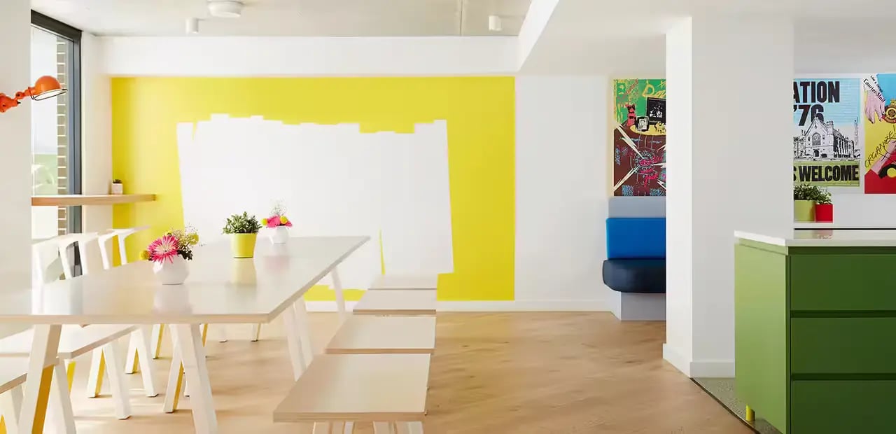 Long table benches flowers artwork colorful communal area at Scape Abercrombie in Sydney Student Accommodation