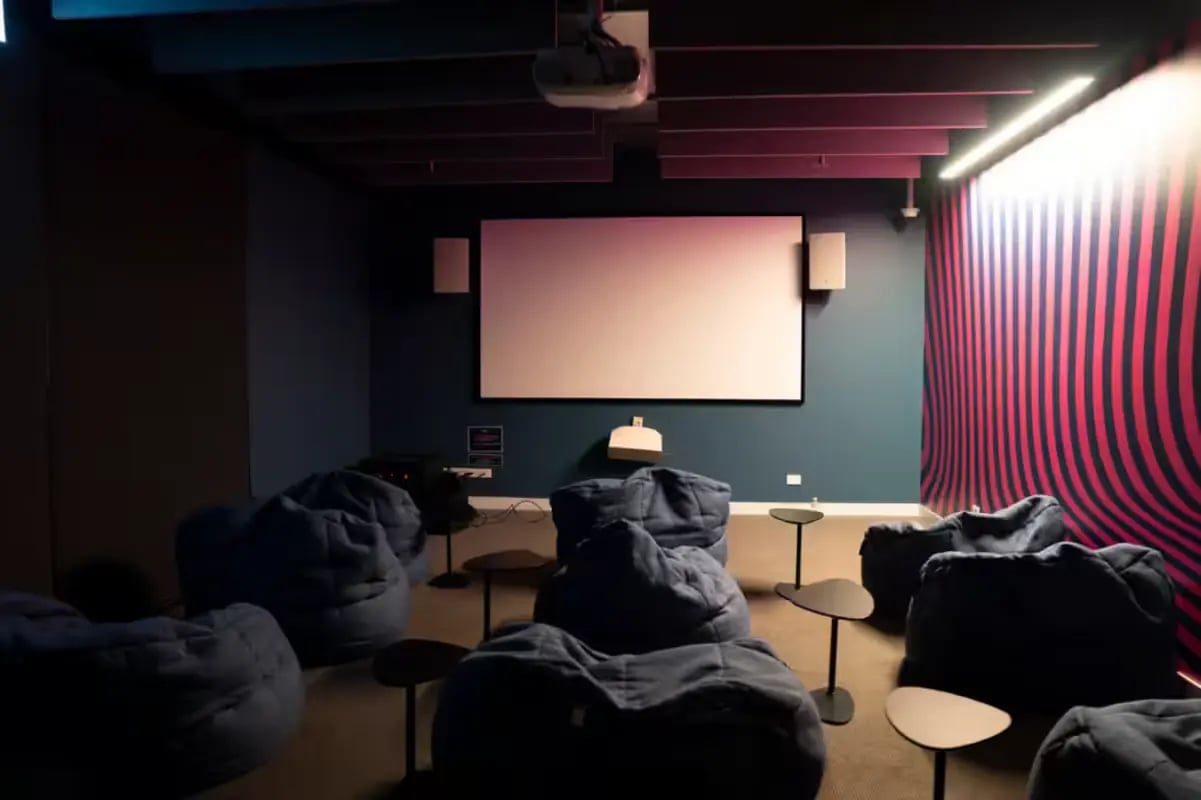 Beanbag chairs and small tables in a cinema room. at Scape Cornell Place in Melbourne Student Accommodation