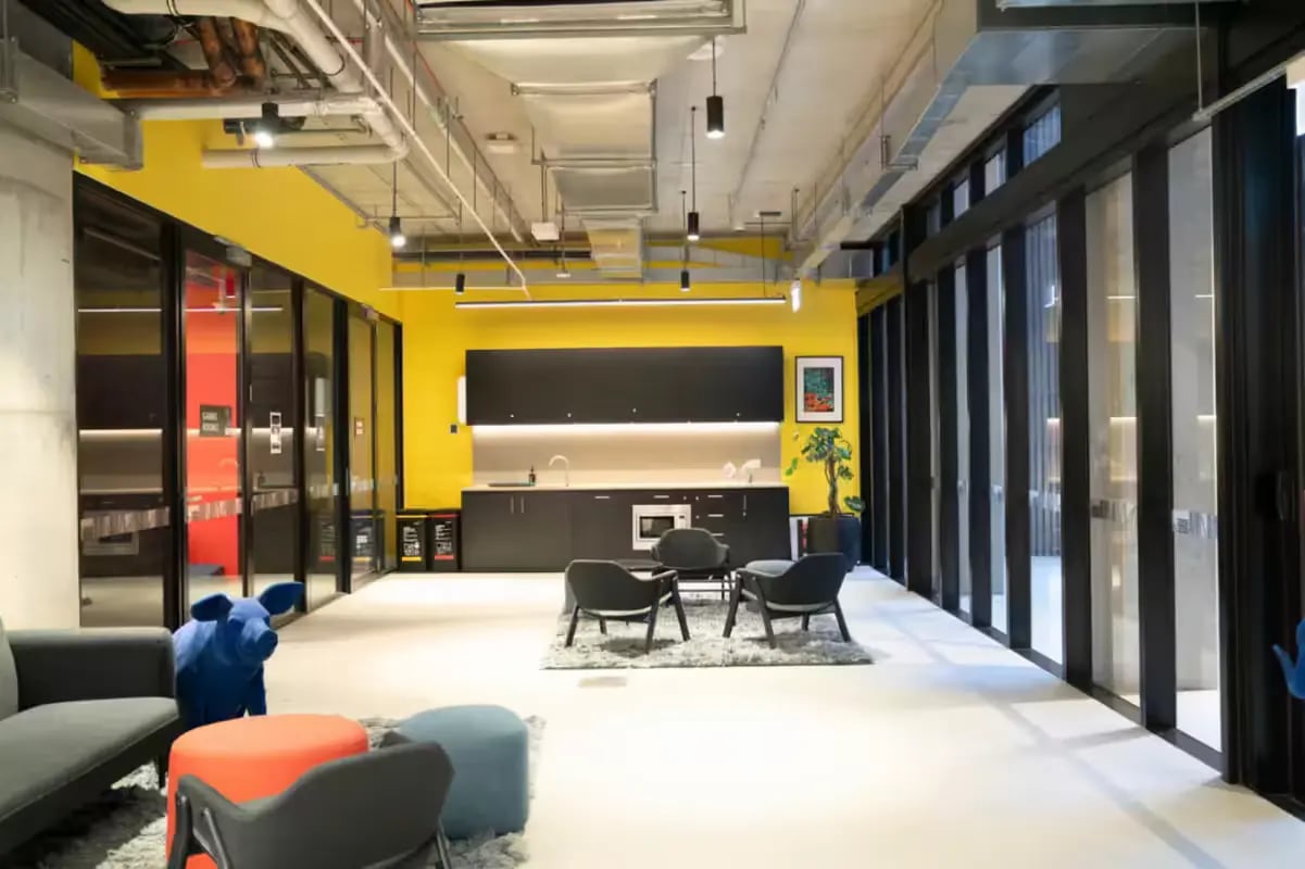 Modern kitchen with lounge area and blue pig seating. at Scape Cornell Place in Melbourne Student Accommodation