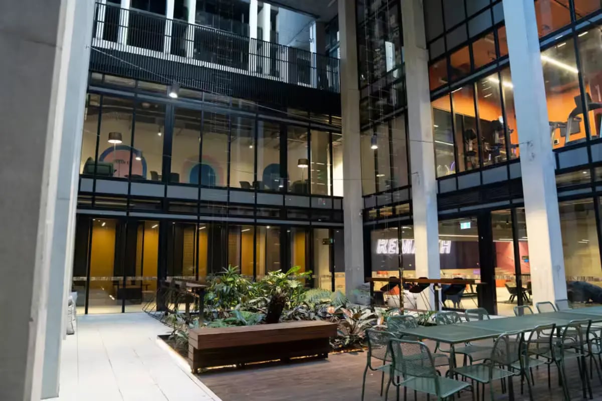 Outdoor seating with plants and modern building exterior area at Scape Cornell Place in Melbourne Student Accommodation