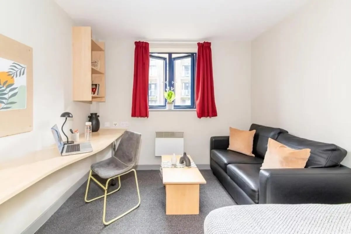 Desk laptop chair sofa coffee table living room at Studio 58 in Bristol Student Accommodation