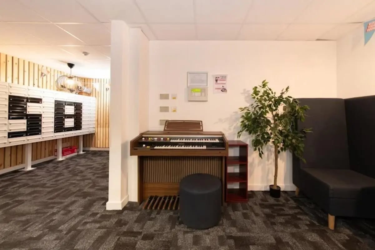 Organ bench artificial plant dark seating common area at Studio 58 in Bristol Student Accommodation