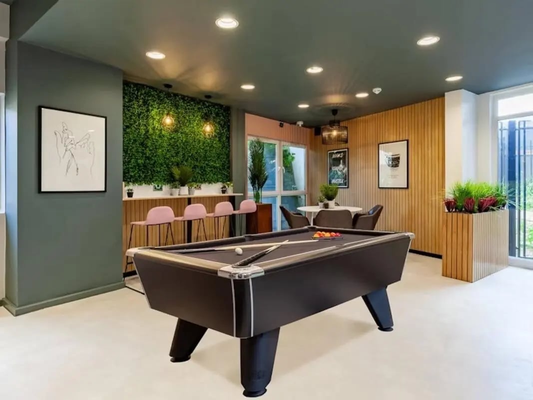 Pool table pink bar stools green wall living area at Filbert Village in Leicester Student Accommodation