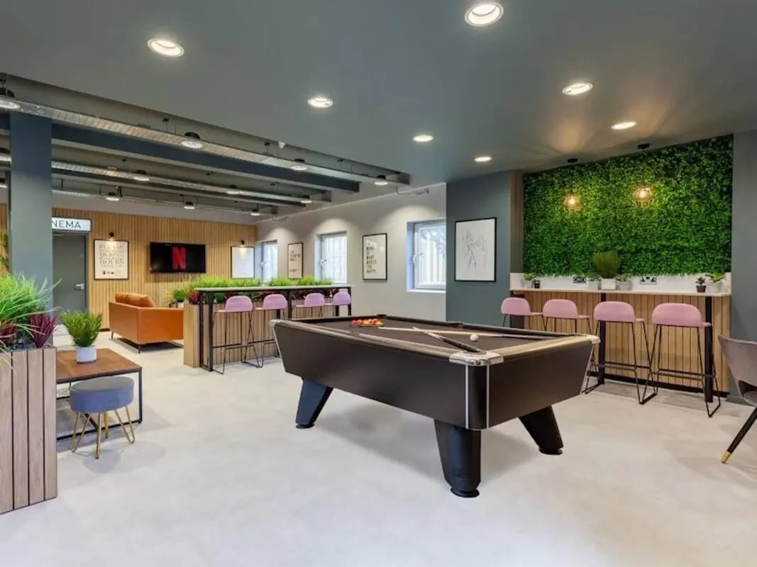 Pool table pink bar stools and orange sofa living area at Filbert Village in Leicester Student Accommodation