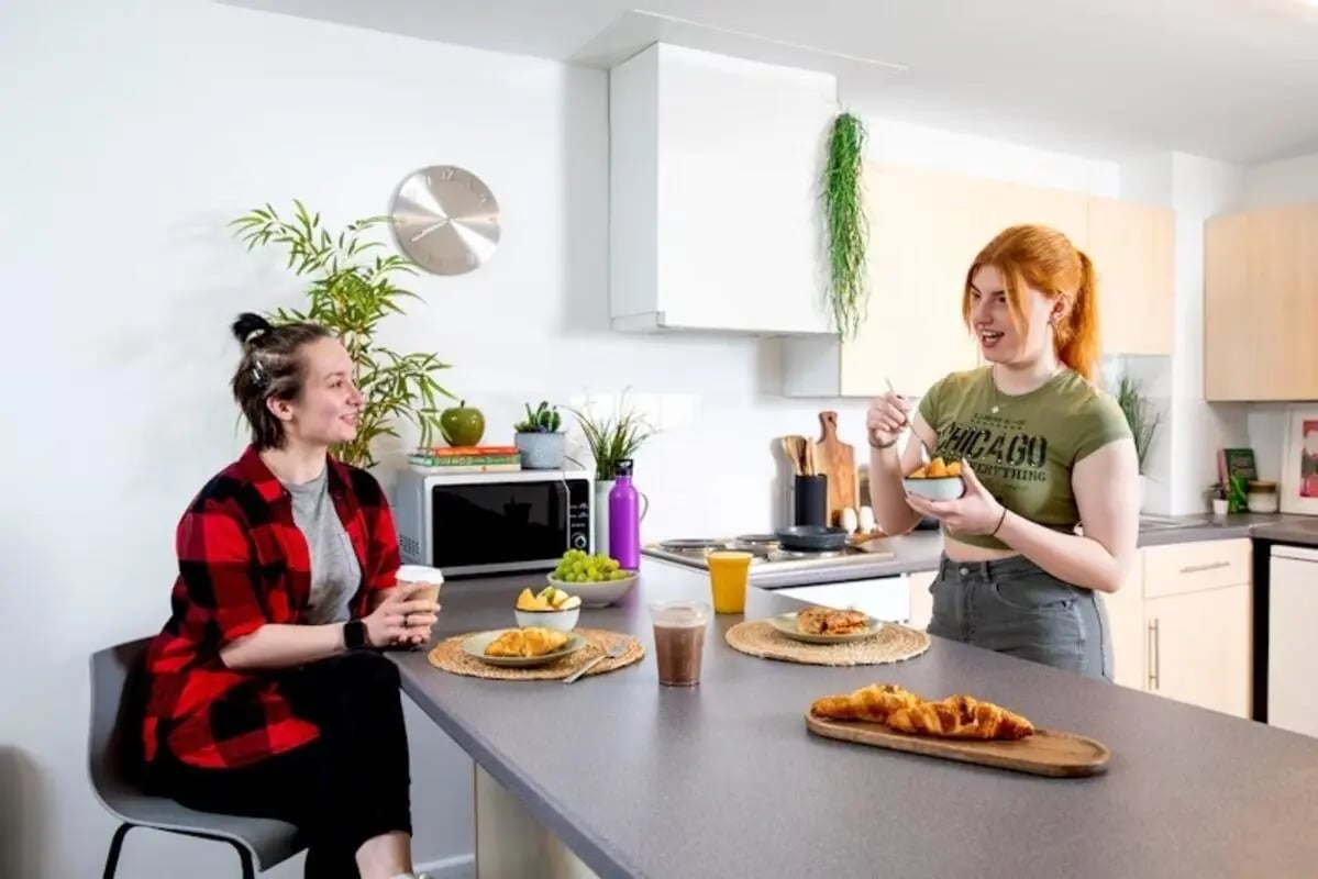 Two students eating breakfast in a modern kitchen at Newarke Point in Leicester Student Accommodation