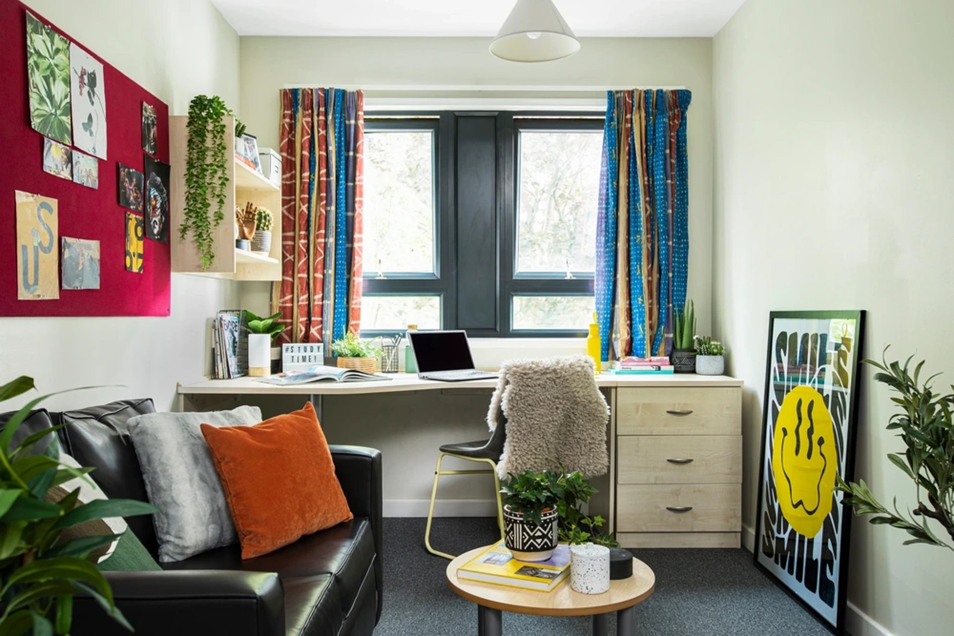 Black leather couch desk and plants Living room at Rahere Court in London Student Accommodation