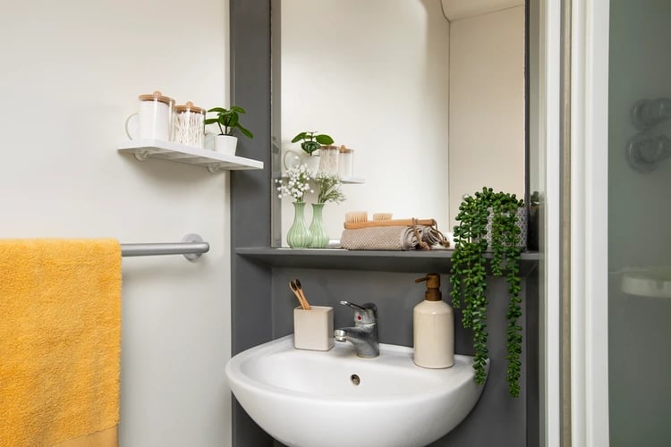 Sink with soap dispenser and yellow towel Bathroom at Wellington Lodge in London Student Accommodation