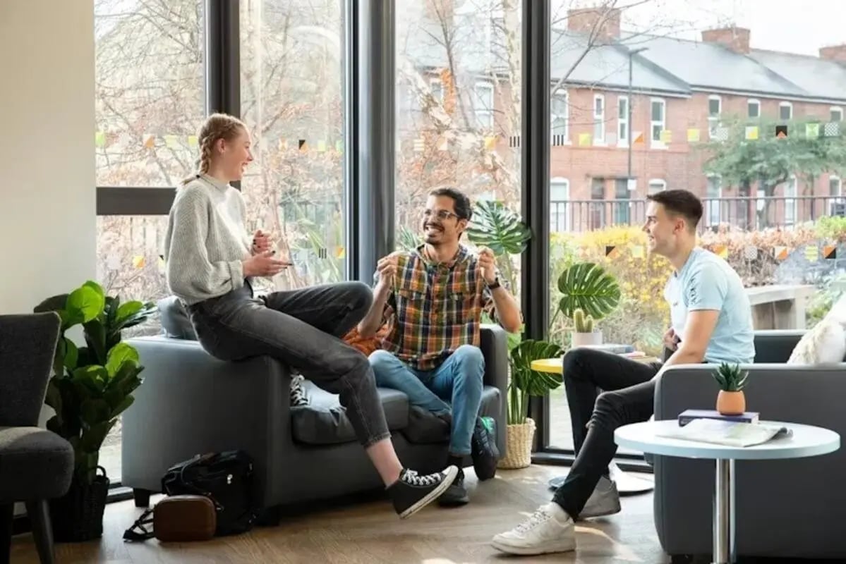 Three students conversing on sofas living room at The Anvil in Sheffield Student Accommodation