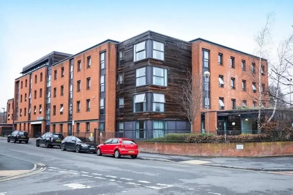 Modern brick building with wood accents and cars exterior at The Anvil in Sheffield Student Accommodation