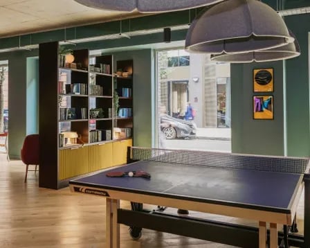 Ping pong table and bookshelves common area at Scape Shoreditch in London Student Accommodation
