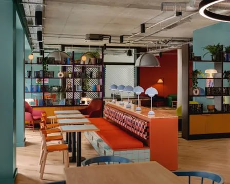 Colorful communal area with booths and tables at Scape Shoreditch in London Student Accommodation