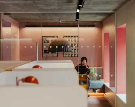 Student working in study pods with pink walls Study area at Scape Shoreditch in London Student Accommodation