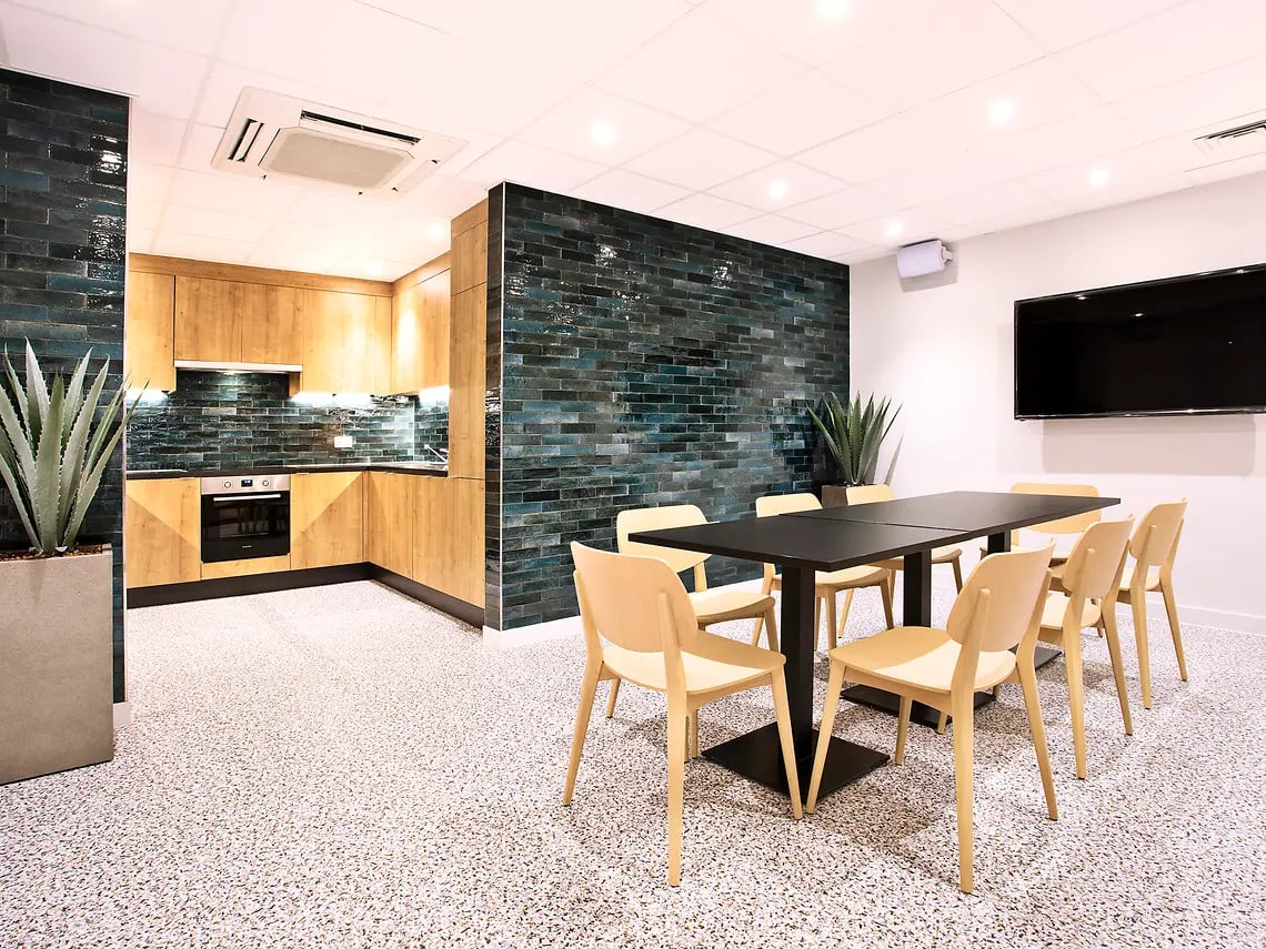 Kitchen dining area with table chairs and TV at The Curve in London Student Accommodation