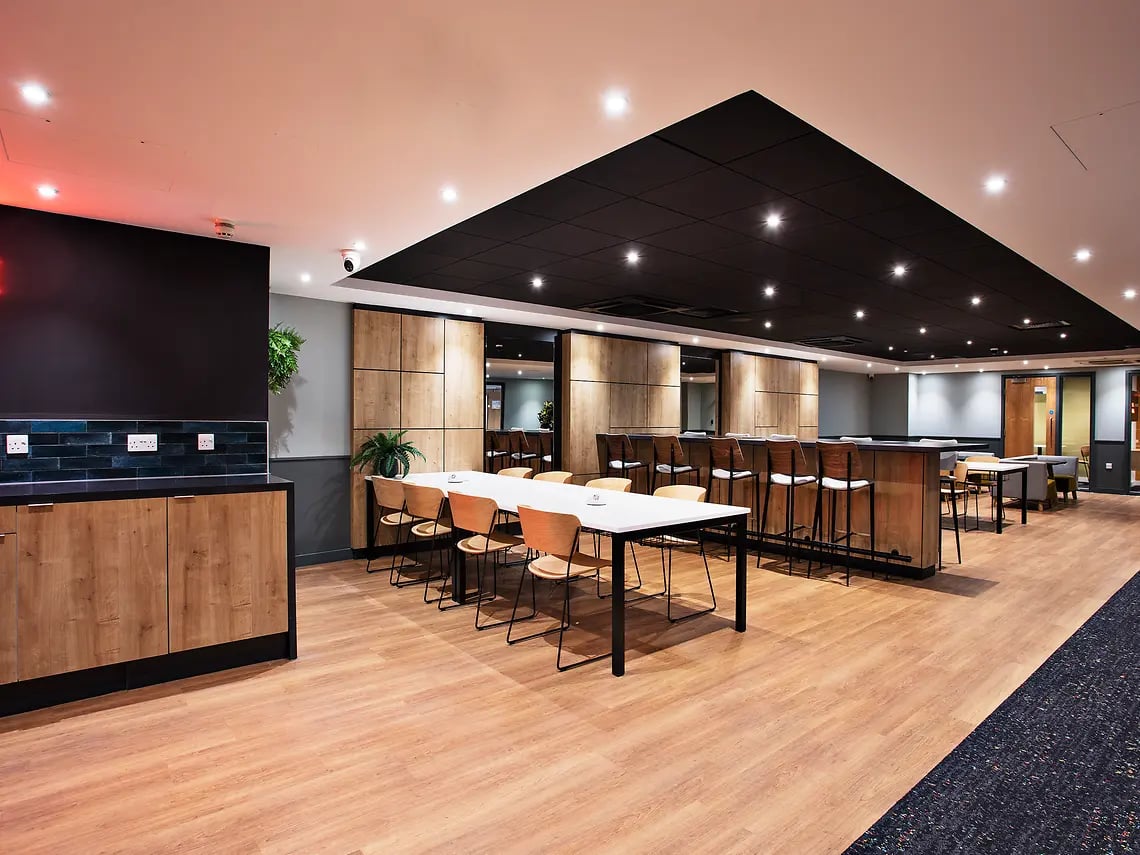 Long table with chairs and bar communal area image at The Curve in London Student Accommodation