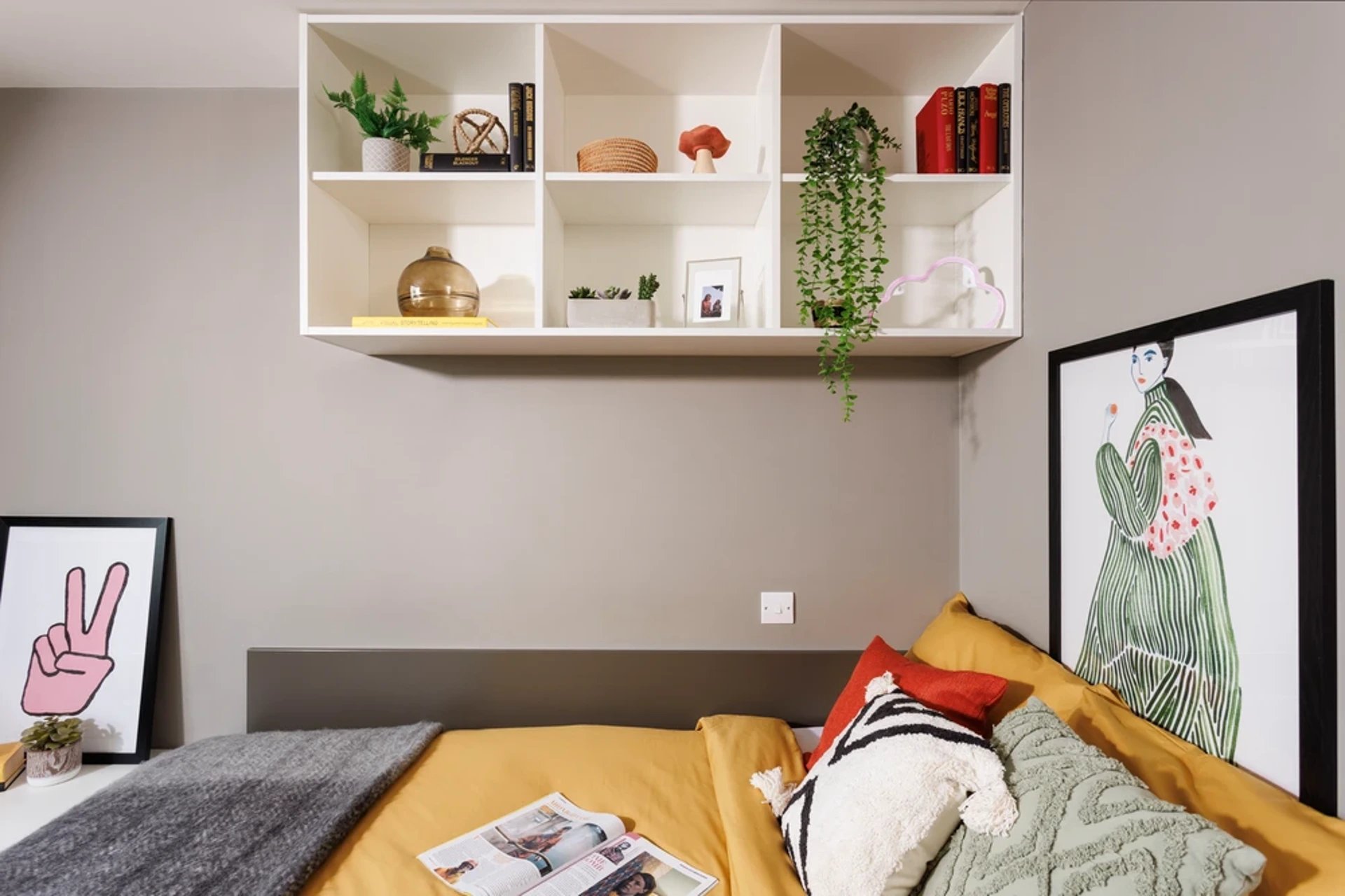 Bed with artwork plant books and decorative shelf Bedroom at Olympic Way in London Student Accommodation
