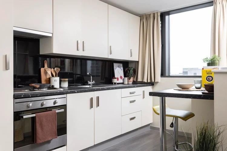 White cabinets stove sink and breakfast bar kitchen at Olympic Way in London Student Accommodation