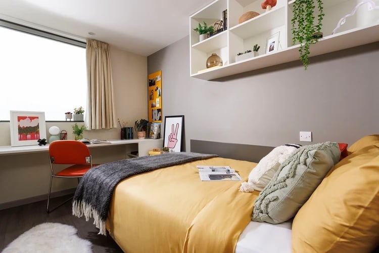 Bed desk chair shelves pillows artwork bedroom at Olympic Way in London Student Accommodation