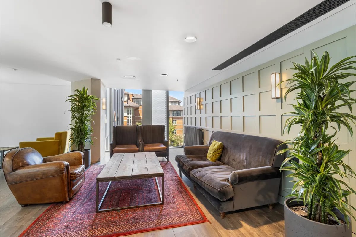 Sofa chairs coffee table patterned rug living room at Chapter Kings Cross in London Student Accommodation