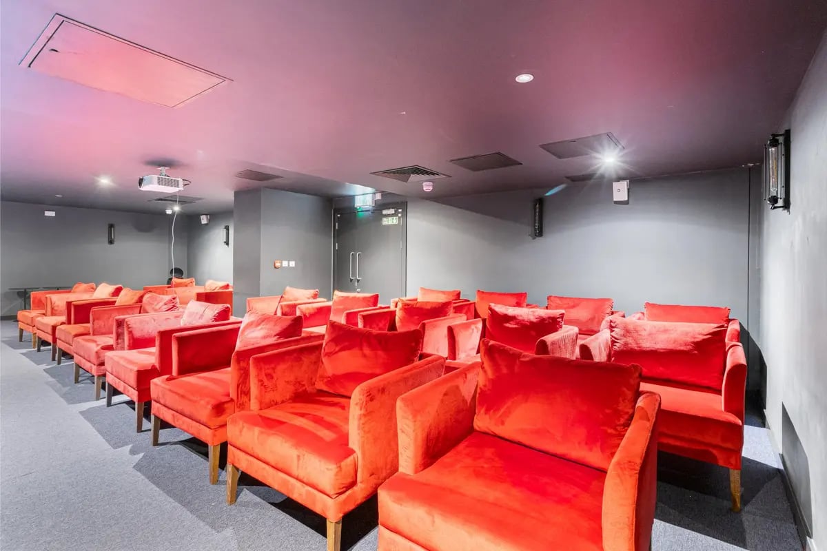 Red plush chairs arranged in rows cinema at Chapter Kings Cross in London Student Accommodation