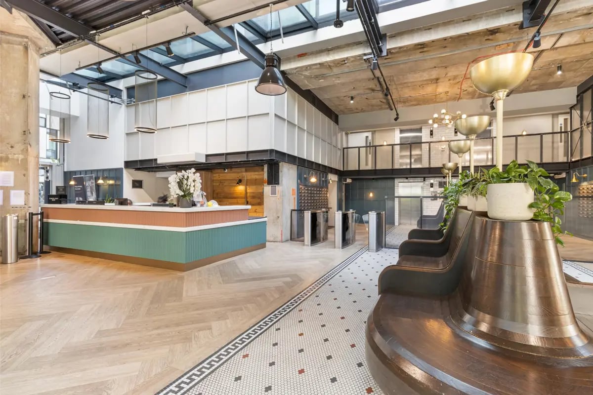 Reception desk with turnstiles and seating area interior at Chapter Kings Cross in London Student Accommodation