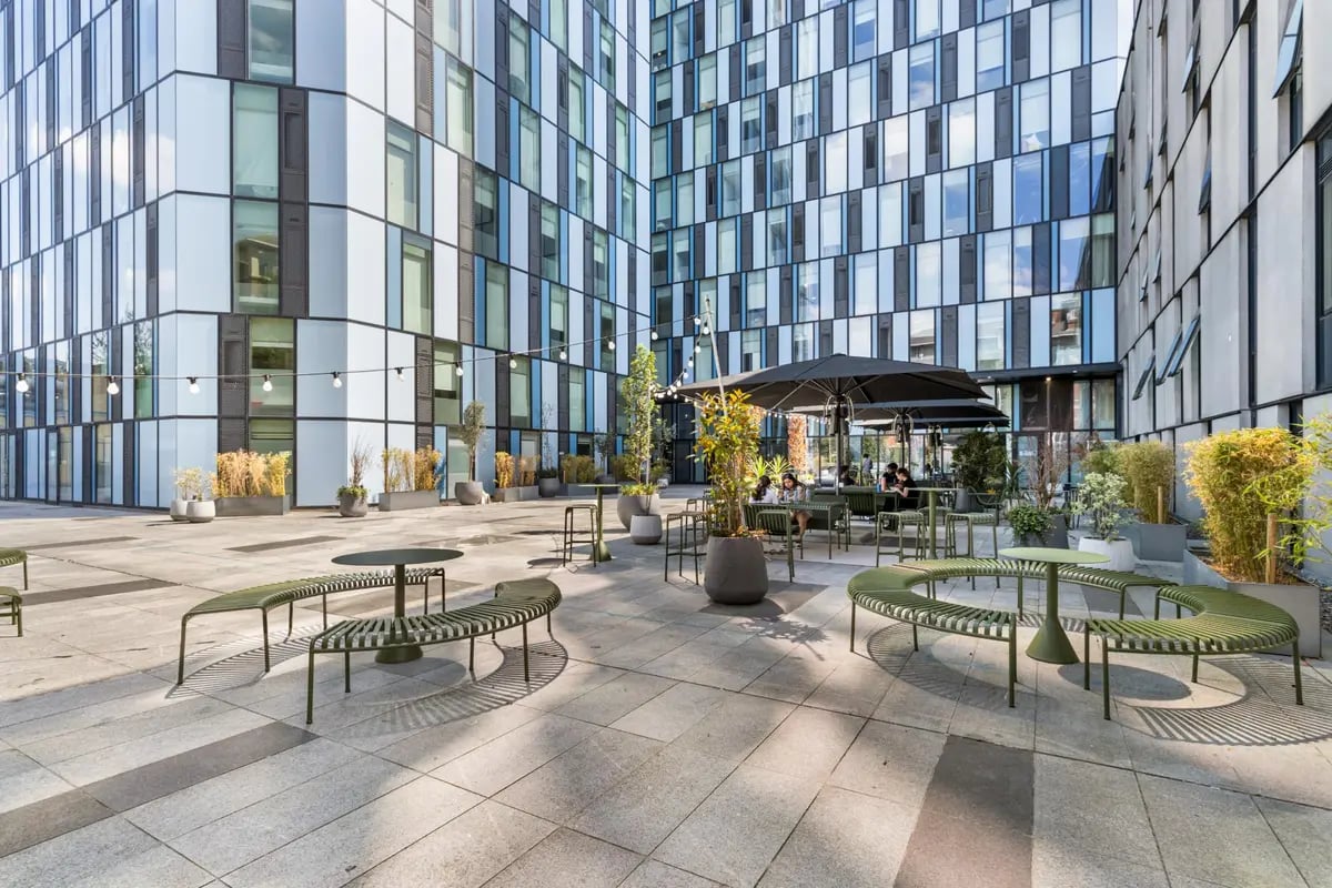 Outdoor seating area with modern benches and tables exterior at Chapter Kings Cross in London Student Accommodation