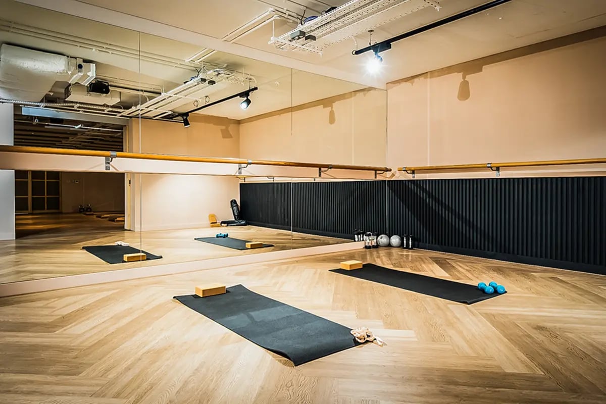 Yoga mats weights barre floor mirrors gym area at Chapter Kings Cross in London Student Accommodation