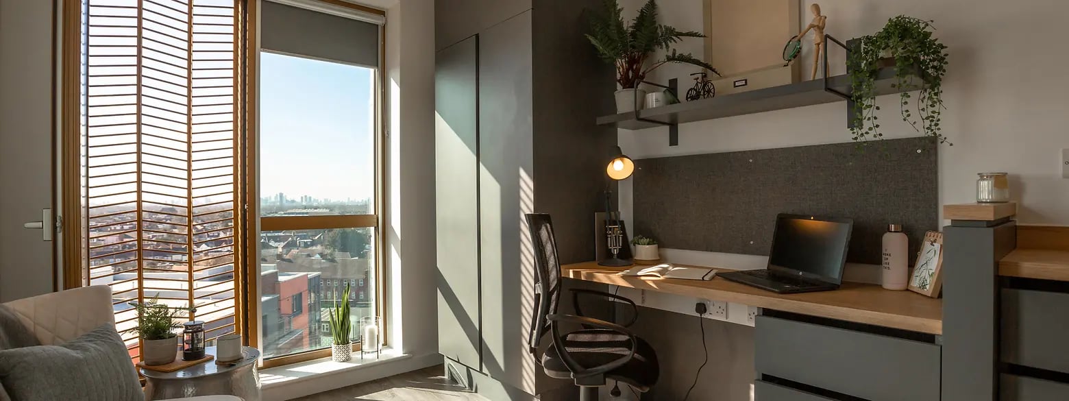 Desk with laptop chair and window view study area at The Valentine London in London Student Accommodation