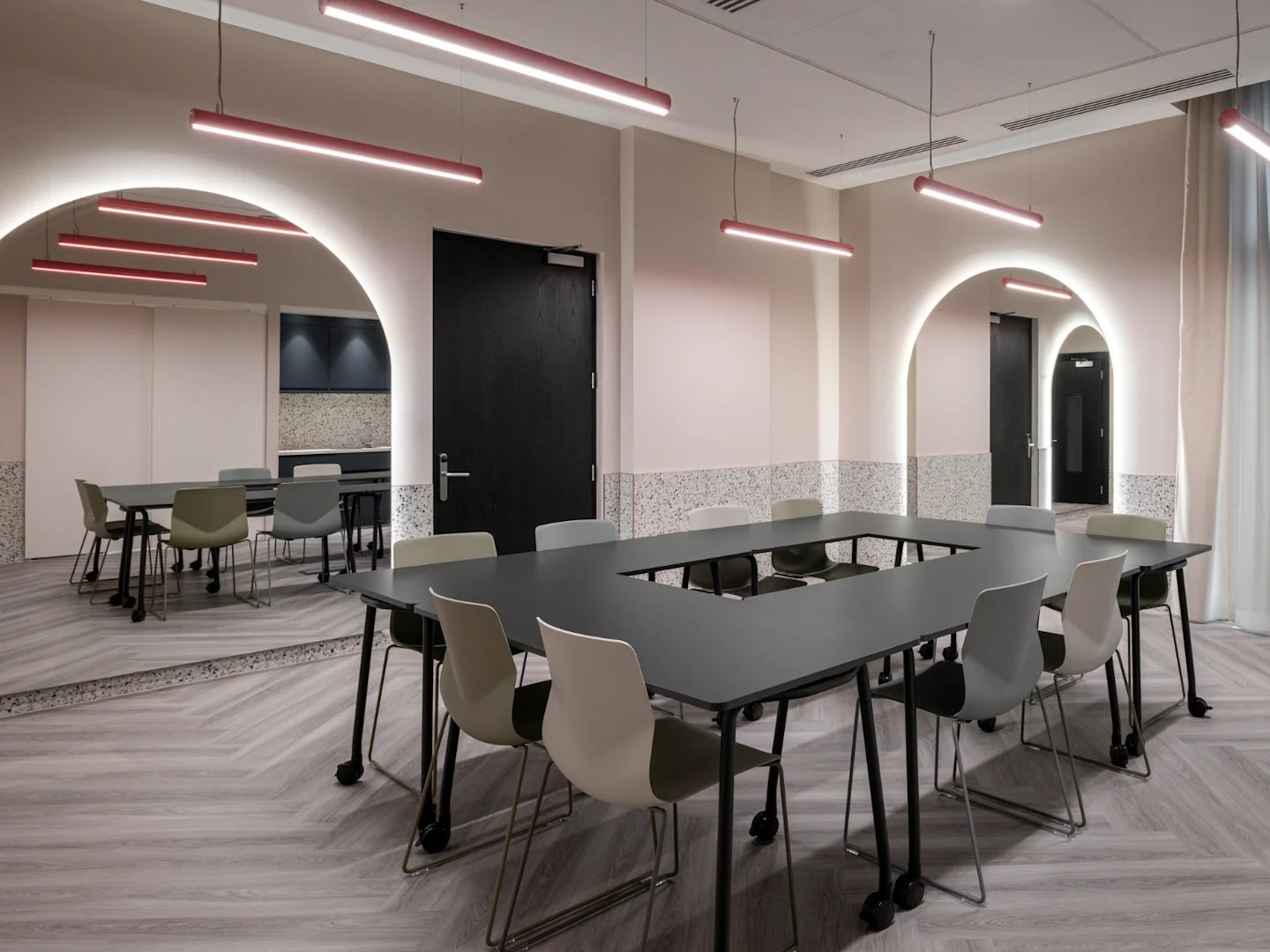 U-shaped table with chairs modern lighting meeting room at Spring Mews in London Student Accommodation
