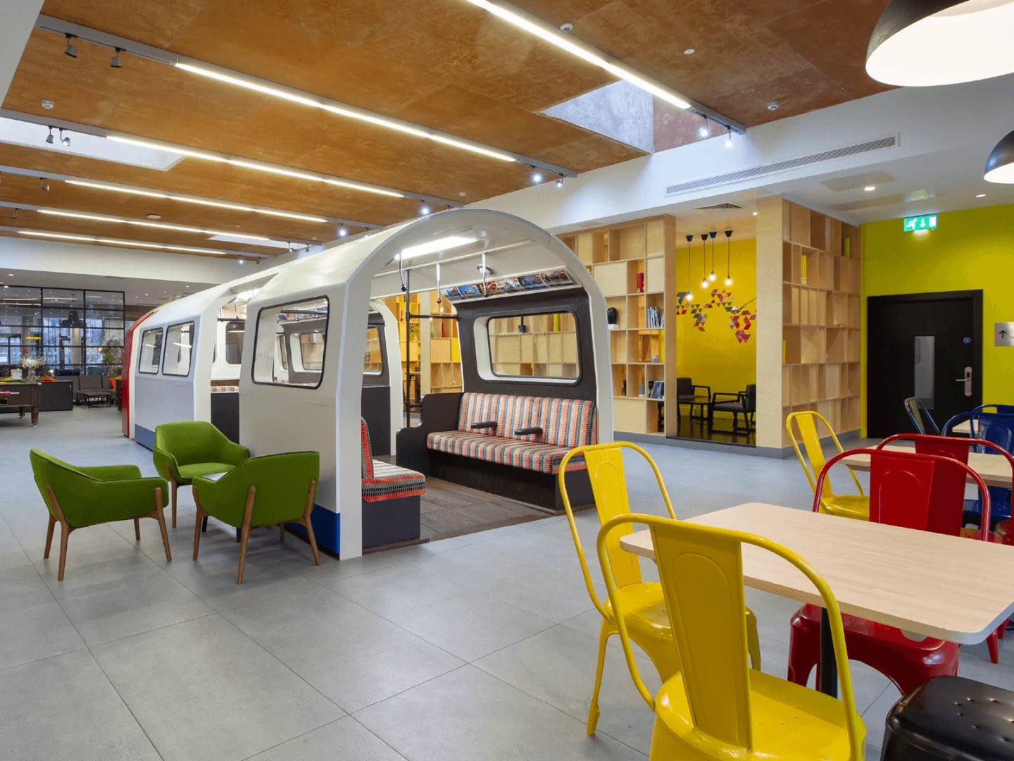 Train-shaped seating area with colorful chairs living room at Spring Mews in London Student Accommodation