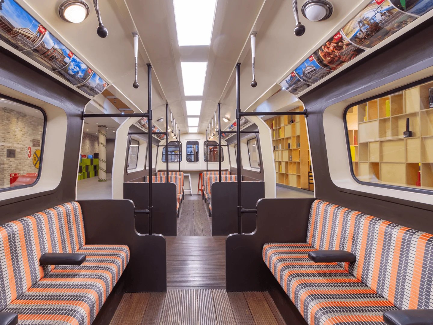 Train carriage seating with shelves beyond communal area at Spring Mews in London Student Accommodation