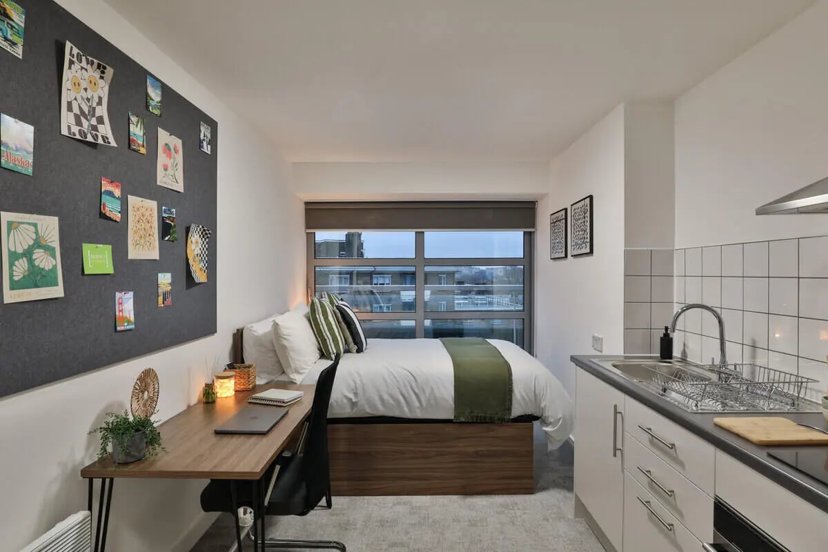 Bed desk kitchen area with sink at AXO Camden in London Student Accommodation