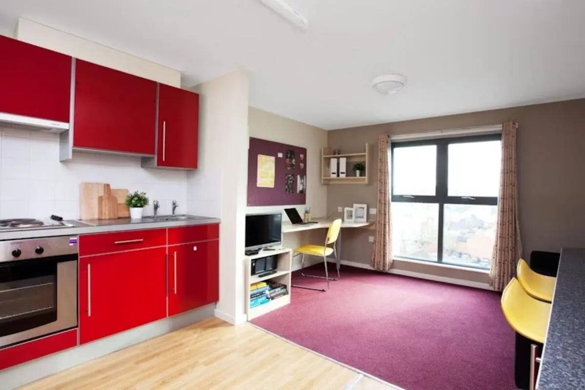 Red kitchen area desk area and living room at Crown House - Reading in Reading Student Accommodation