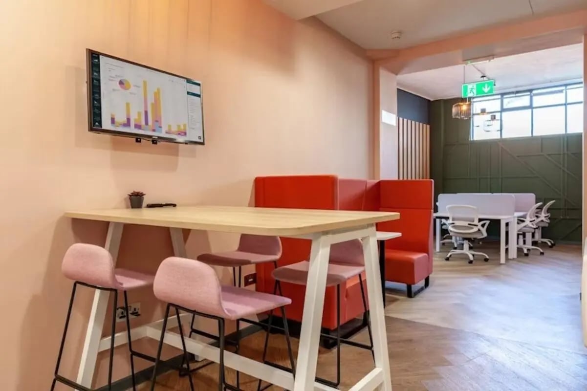 High table with pink chairs then office desks study area at Crown House - Reading in Reading Student Accommodation
