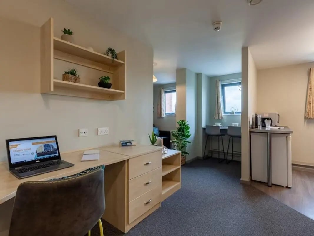 Desk laptop plants kitchenette seating study area studio at Crown House - Reading in Reading Student Accommodation