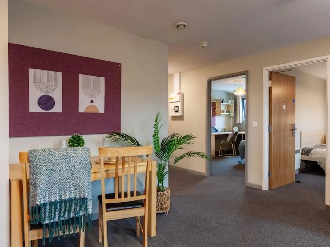 Dining table chairs artwork plant hallway and bedroom at Crown House - Reading in Reading Student Accommodation
