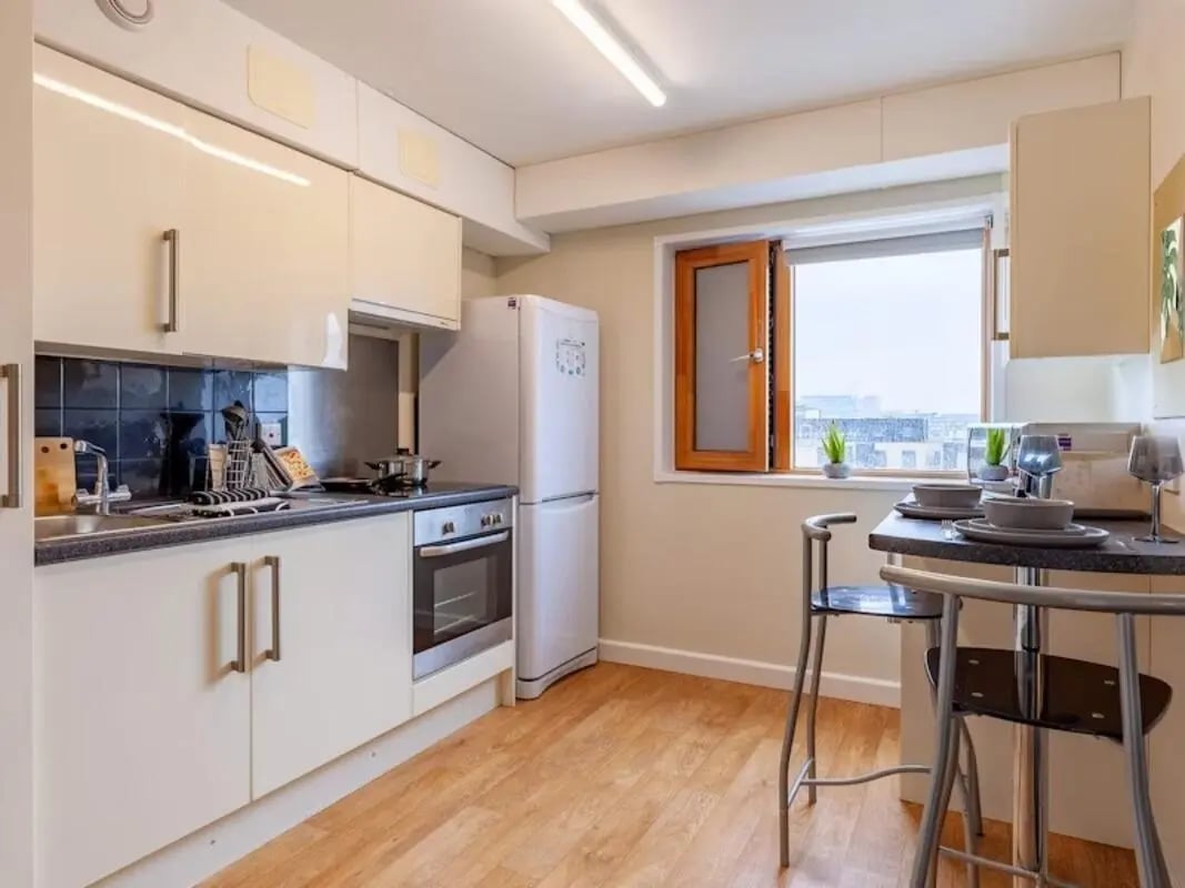 White cabinets fridge oven sink dining bar kitchen at Kendrick Hall in Reading Student Accommodation