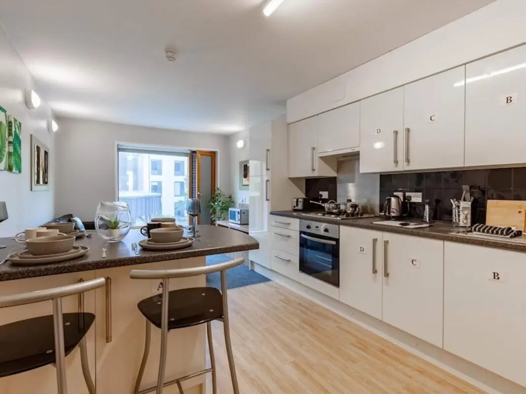 Kitchen island with stools and modern white kitchen cabinets Kitchen at Kendrick Hall in Reading Student Accommodation