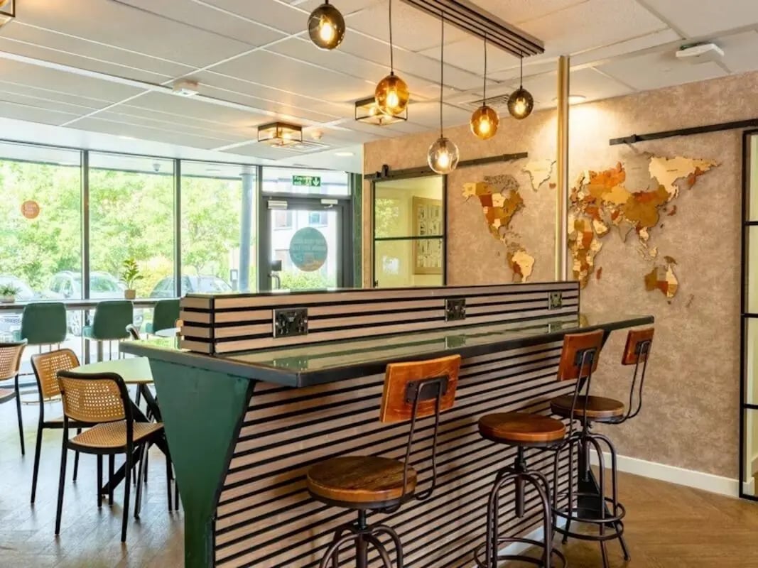 Bar stools and tables with world map living area at Kendrick Hall in Reading Student Accommodation