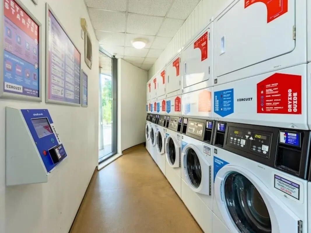 Washing machines dryers payment kiosk laundry room at Kendrick Hall in Reading Student Accommodation