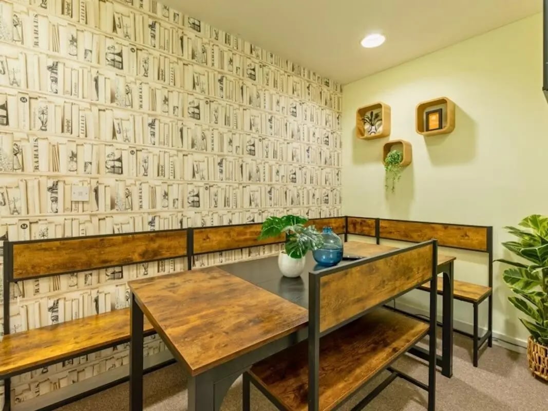 Dining table with benches bookshelf wallpaper dining area at Kendrick Hall in Reading Student Accommodation