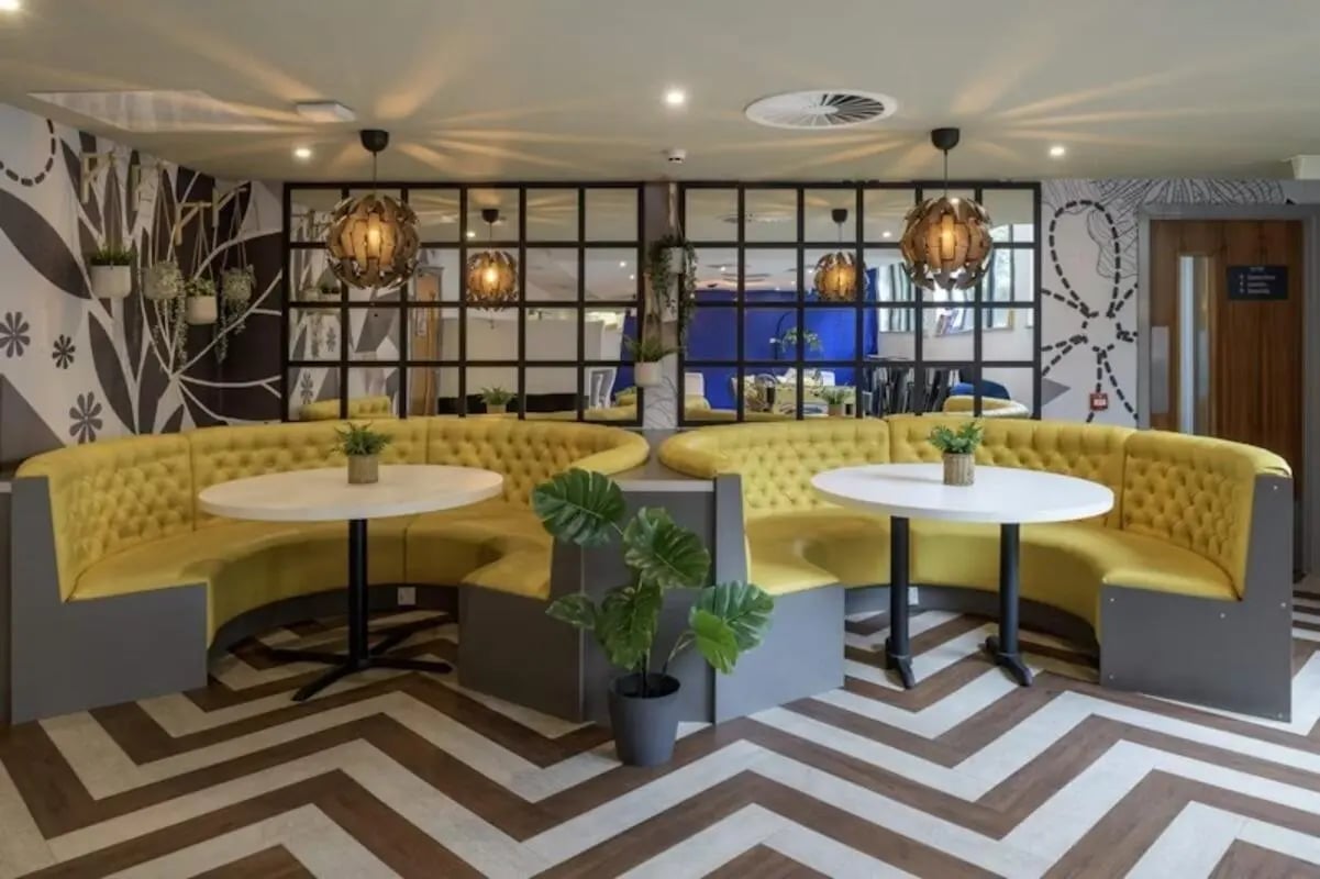 Yellow booths with white tables common area at King Square Studios in Bristol Student Accommodation