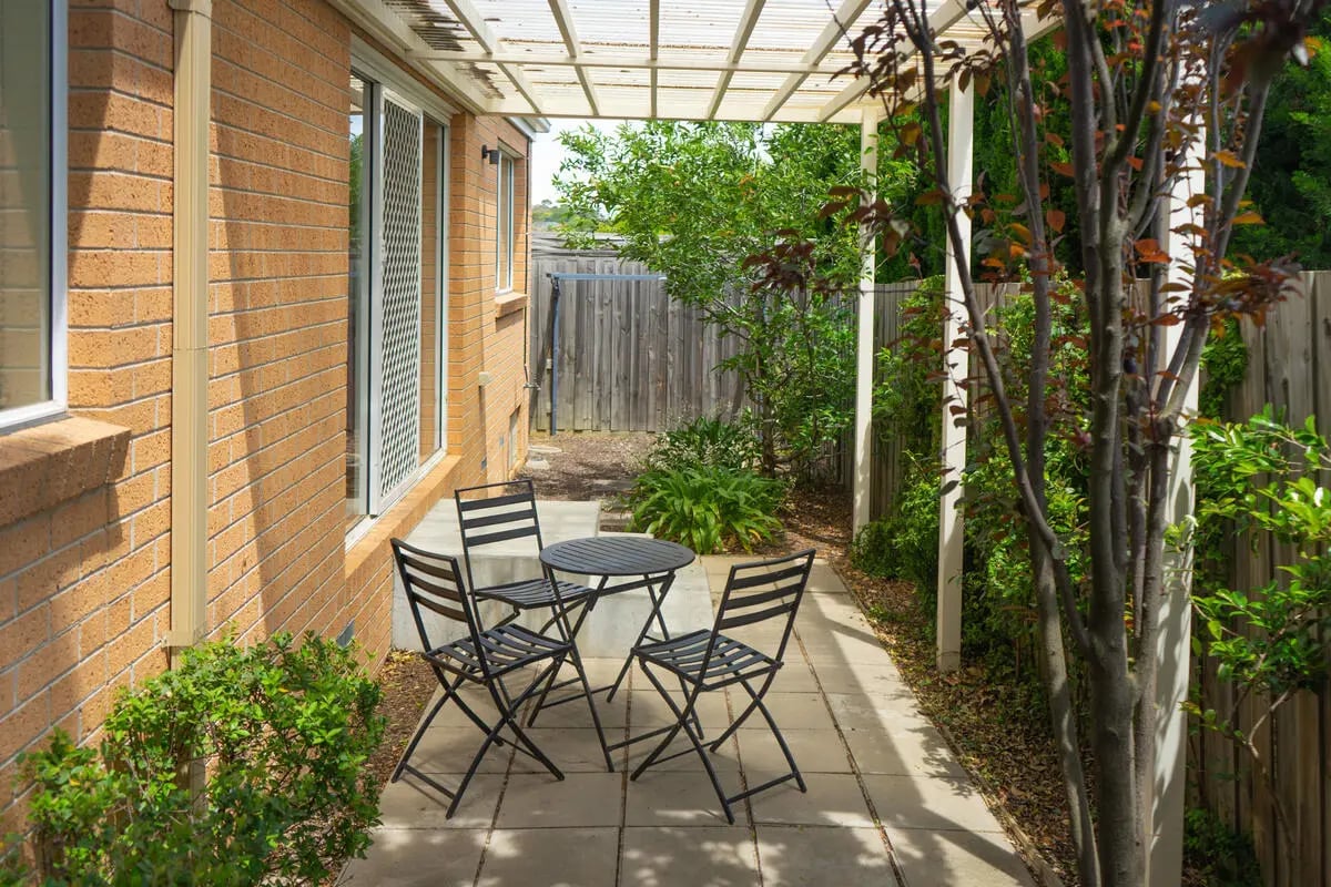 Table chairs patio with green garden exterior at Sunset House in Melbourne Student Accommodation