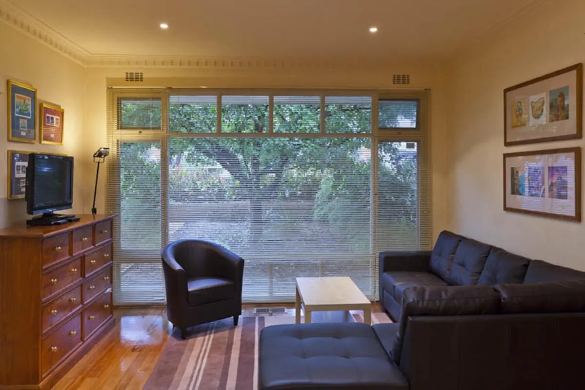 Leather sofa armchair dresser and TV living room at Park Lane House in Melbourne Student Accommodation
