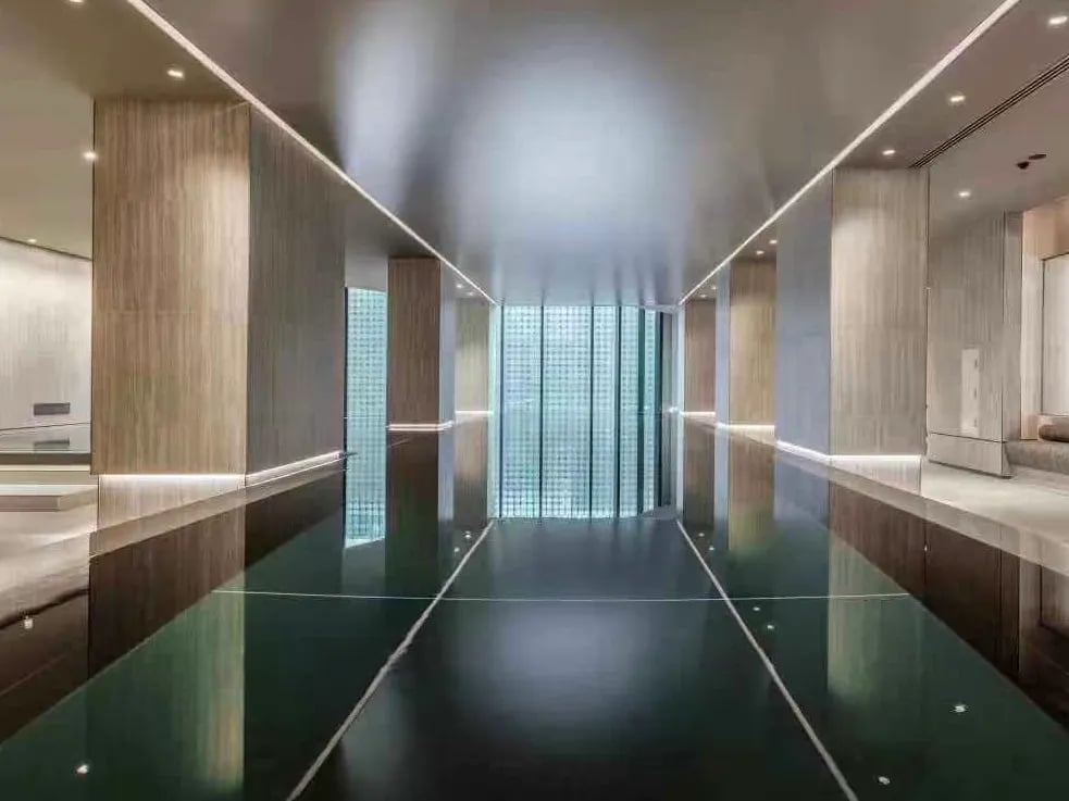 Glossy indoor swimming pool with wood paneling and glass walls. at Belong Melbourne CBD in Melbourne Student Accommodation