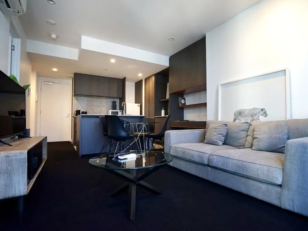 Sofa kitchen island dining table living room at Belong Melbourne CBD in Melbourne Student Accommodation