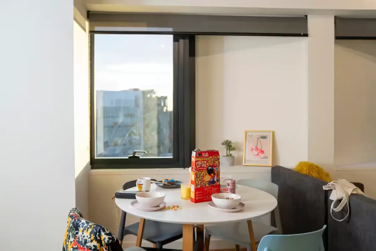 Table with cereal and bowls living room at Scape Carlton in Melbourne Student Accommodation