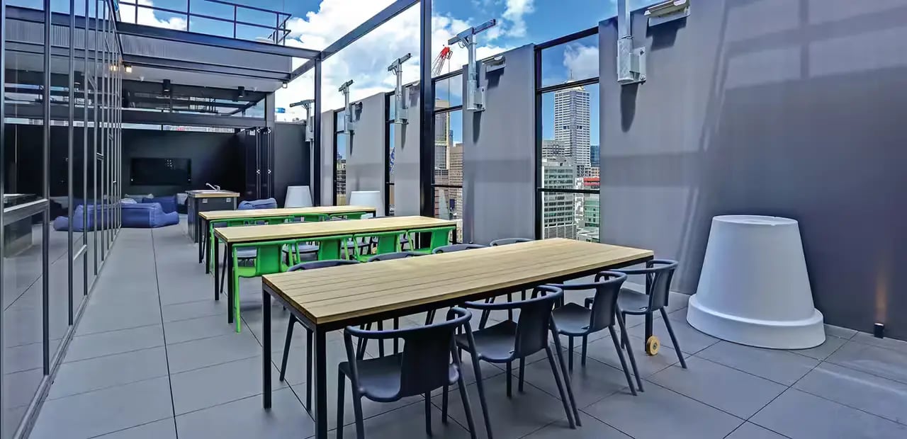 Tables chairs beanbags and city view common area at Scape Melbourne Central in Melbourne Student Accommodation